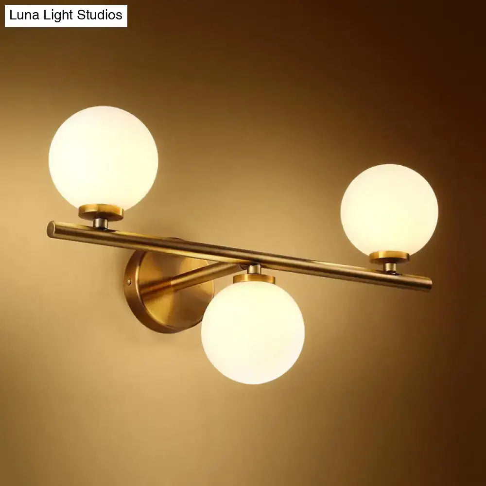 Modern gold 3-light wall sconce with brass finish and white frosted glass shades for bedroom wall light