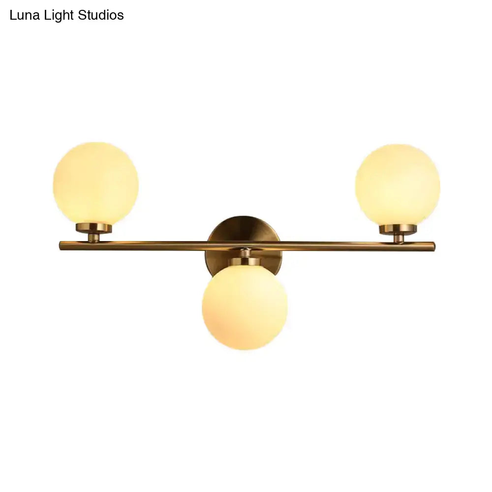 Modern gold 3-light wall sconce with brass finish and frosted white glass shades for bedroom wall light