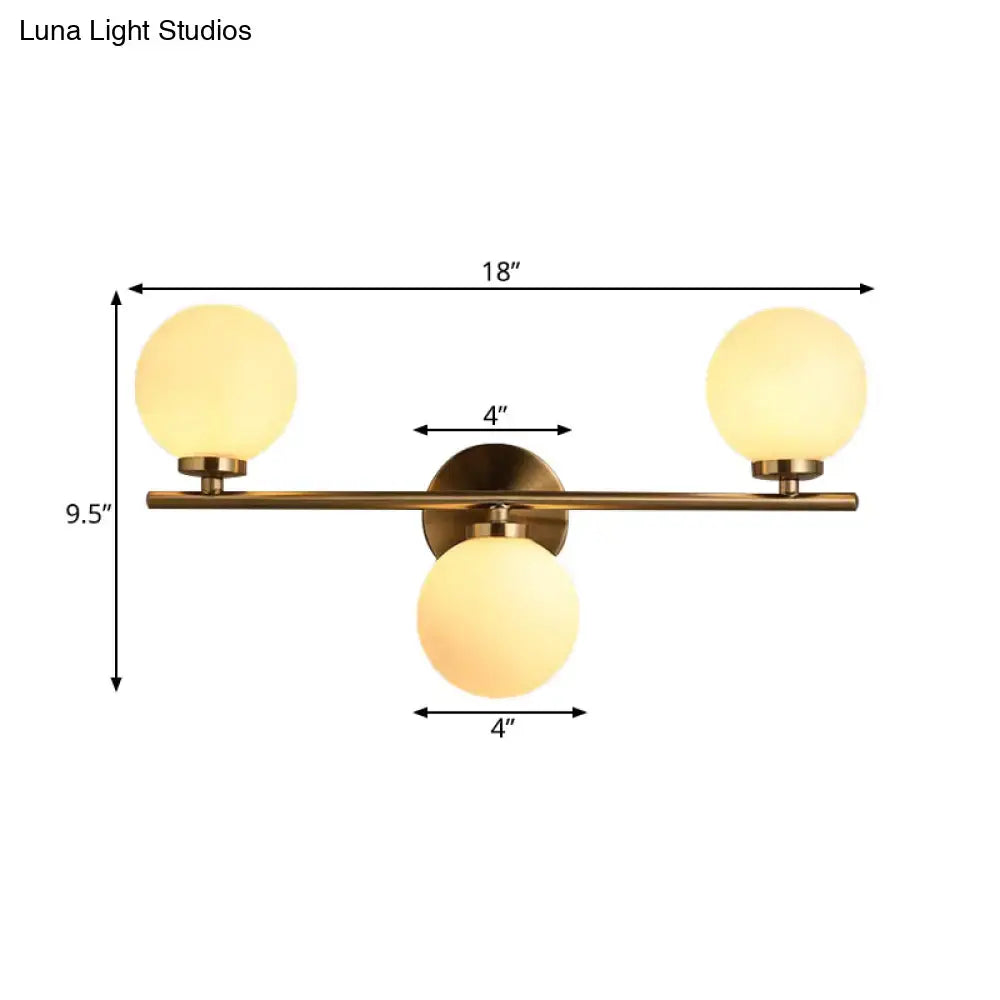 Modern gold three-light wall sconce with brass finish and white glass shades for bedroom wall light decor