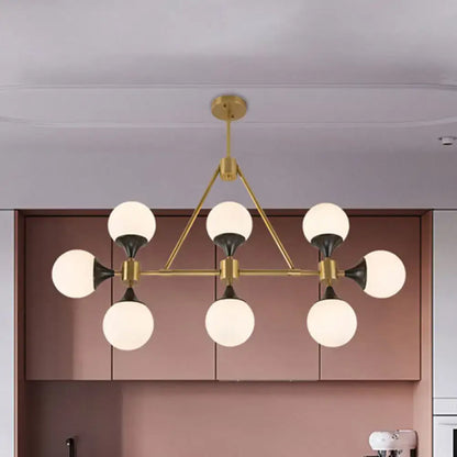 Modern gold decorbites metal chandelier with six frosted glass globe shades and black accents for island lighting
