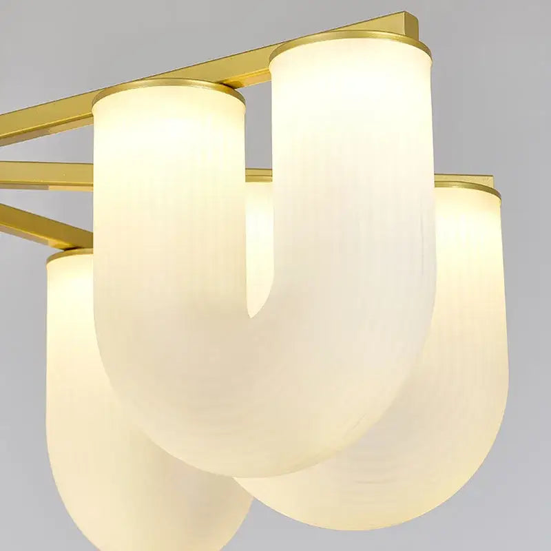 Modern gold acrylic pendant lights featuring three curved frosted glass shades on a gold metal frame for dining room