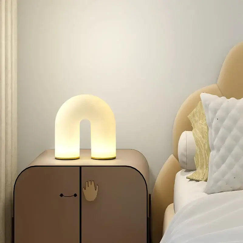 Modern gold acrylic pendant lights featuring a soft glowing u-shaped lamp with a smooth matte finish for dining room use