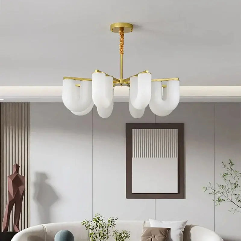 Modern gold acrylic pendant lights featuring a gold metal chandelier with six frosted white cloud-shaped shades