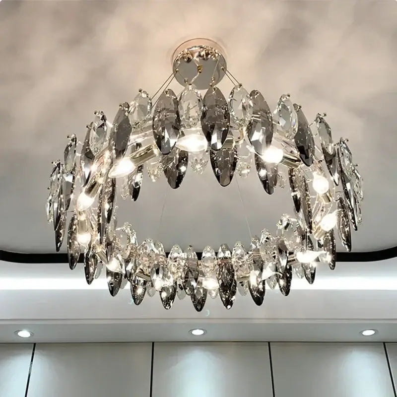 A modern gold amber decorbites crystal ceiling chandelier with two-tiered clear and silver-toned glass pieces for dining room