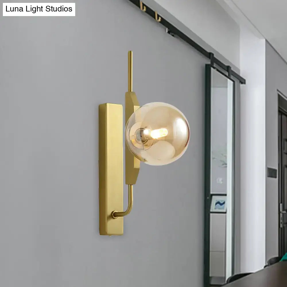 Modern gold and amber glass orb wall light fixture with spherical bulb suitable for 110v-120v bedroom use