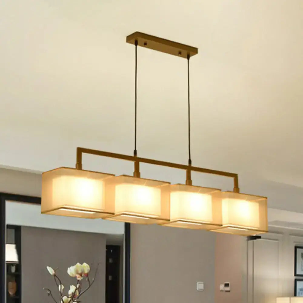 Modern gold and beige fabric island light with four warm-toned shades and brass frame for suspension lighting use