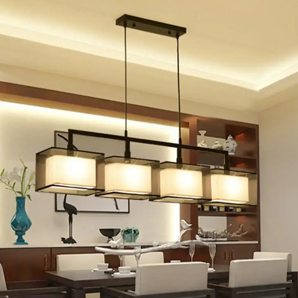 Modern gold and beige fabric island light with four warm-toned shades and black metal arms for suspension lighting
