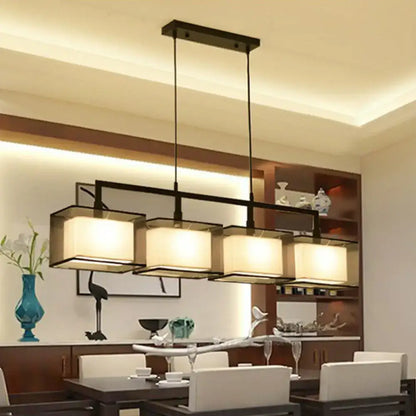 Modern gold and beige fabric island light with four warm-toned shades and black metal arms for suspension lighting