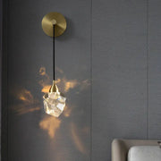Modern gold and black crystal wall sconce with faceted clear shade refracting warm light from the decorbites crystal wall collection