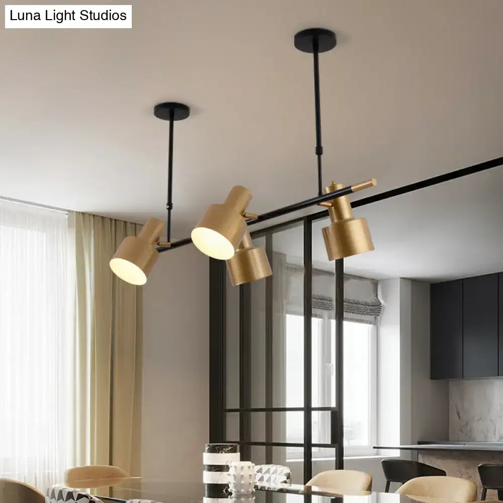 Modern gold and black drum pendant light with adjustable arms and cylindrical shades for dining room island lighting