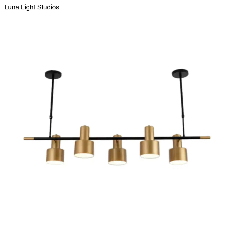 Modern black and gold pendant light with five cylindrical brass shades for dining room island illumination