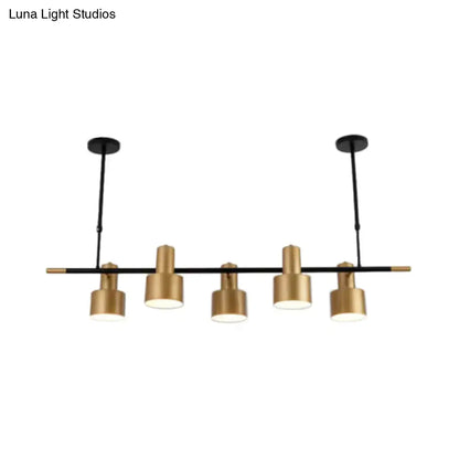 Modern black and gold pendant light with five cylindrical brass shades for dining room island illumination