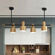 Modern gold and black drum pendant light with cylindrical shades and metal fixtures for dining room island lighting