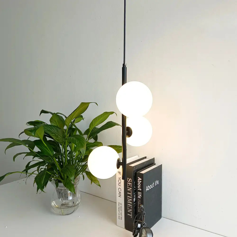 Modern black metal pendant light with three frosted white glass ball led globes for elegant bedroom lighting