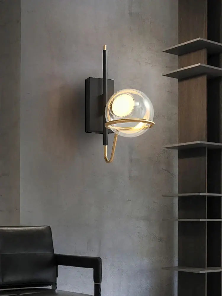 Modern gold and black glass ball pendant light with clear glass globe and metal frame mounted on black backplate for living room decorbites glass ball pendant