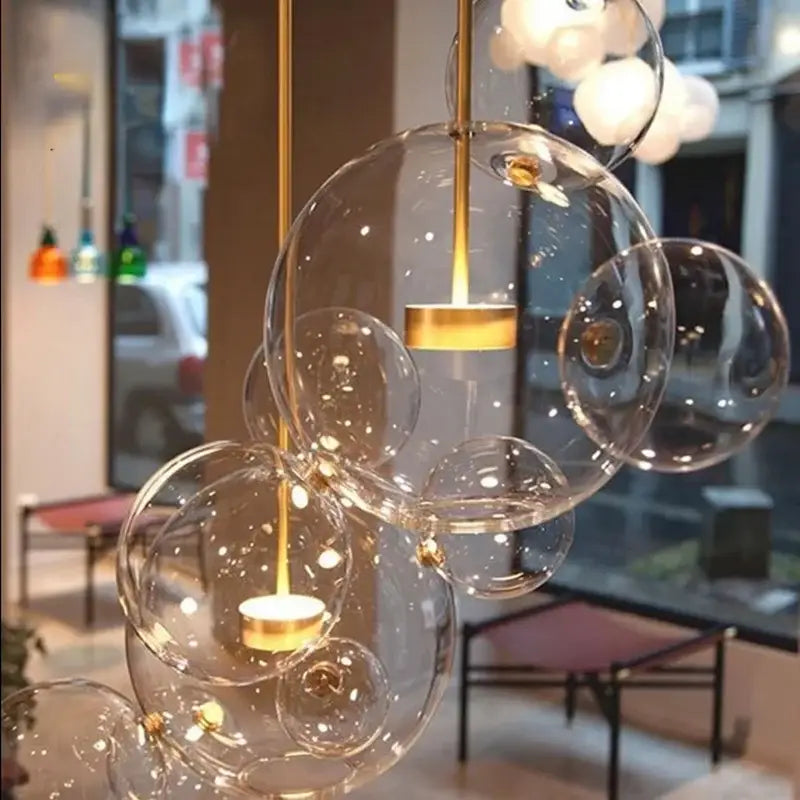 Modern gold and black glass chandelier featuring a clear bubble glass pendant with gold-toned metal and candle bulbs decorbites glass chandelier