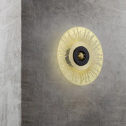 Modern gold and black laser cut disk wall sconce with sunburst design in metal for bedroom lighting