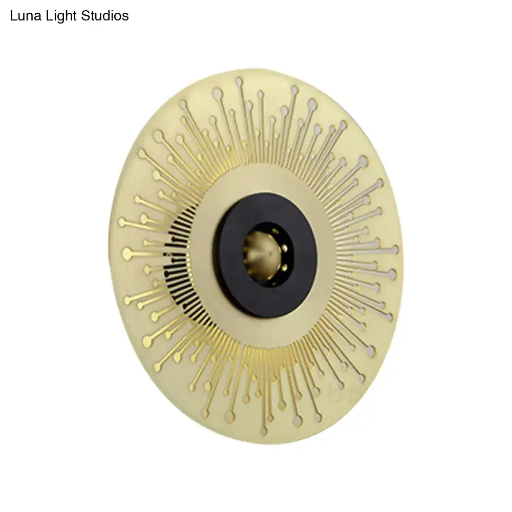 Modern gold and black laser cut disk wall sconce with sunburst design and black central accent for bedroom lighting
