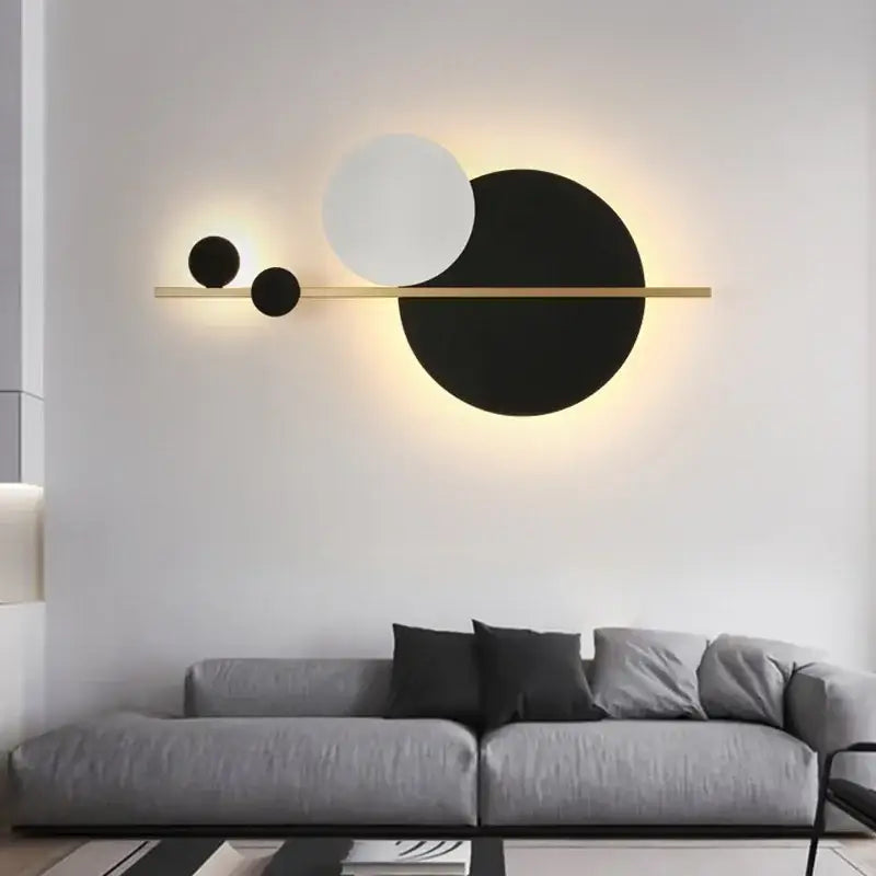 Modern gold and black led wall lamp featuring a sleek bar with three circular shades emitting warm ambient light