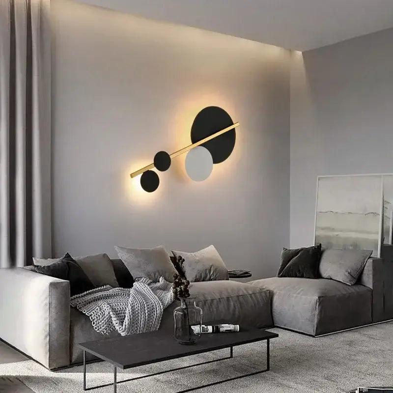 Modern gold and black led wall lamp with three circular discs on a sleek horizontal bar for bedroom use