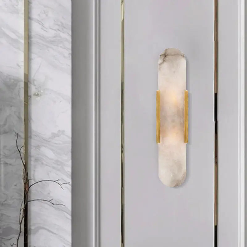 Modern gold and black orb wall lamp with translucent white marble-like body and polished gold metal accents for living rooms