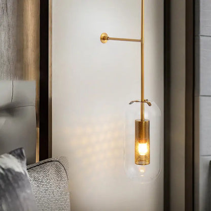 Modern gold and black orb wall lamp with gold-toned sconce, clear glass shade, and mesh cylindrical base for living rooms