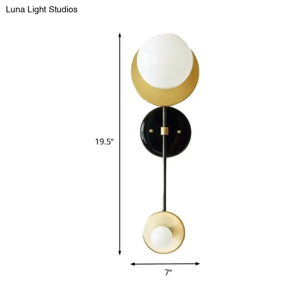 Modern gold and black wall sconce featuring minimalist design with opal glass shade for bedroom lighting