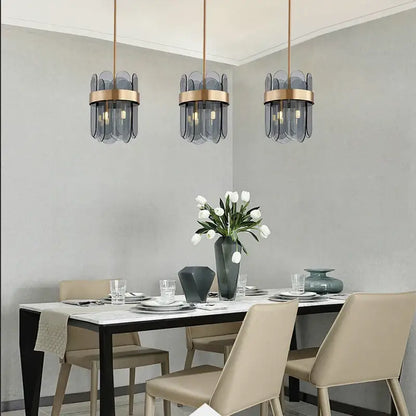 Three modern pendant lights with frosted glass shades and brass accents form a stylish glass chandelier lighting solution