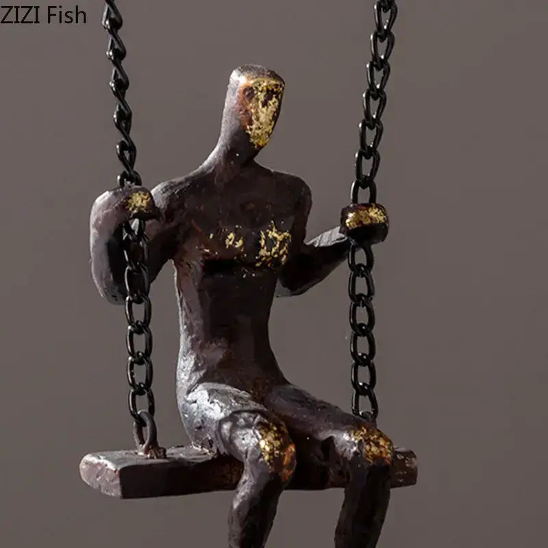 Abstract bronze figurine sitting on a swing with gold leaf details modern golden swing metal sculpture decorbites