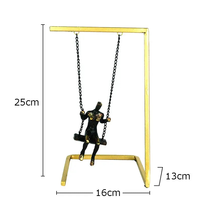 Modern gold and bronze swing metal sculpture featuring a black and gold figurine on a golden metal stand decorbites golden swing