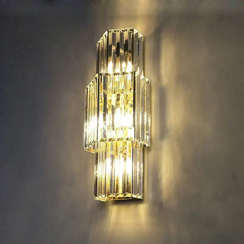 Modern gold and clear crystal led wall sconce with tiered vertical prismatic bars and warm lighting decorbites crystal led wall