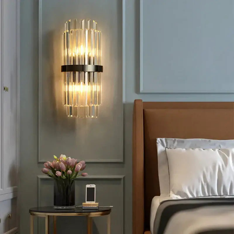 Modern gold and clear crystal led wall sconce with vertical glass rods and sleek black metal frame for bedroom decorbites crystal led lighting