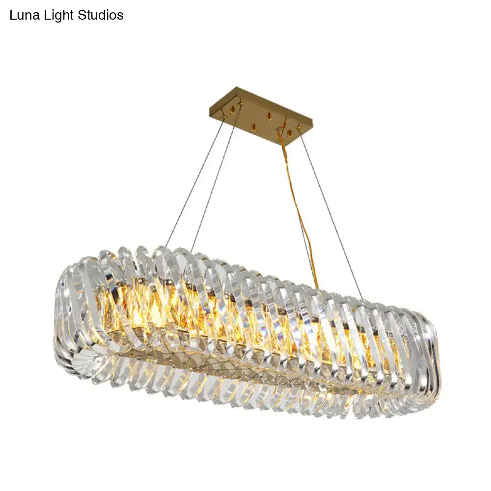 Modern gold pendant light with clear crystal elements in overlapping bands for dining room use