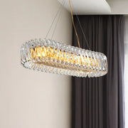 Modern gold and clear crystal oval pendant light with faceted crystal elements for dining room illumination