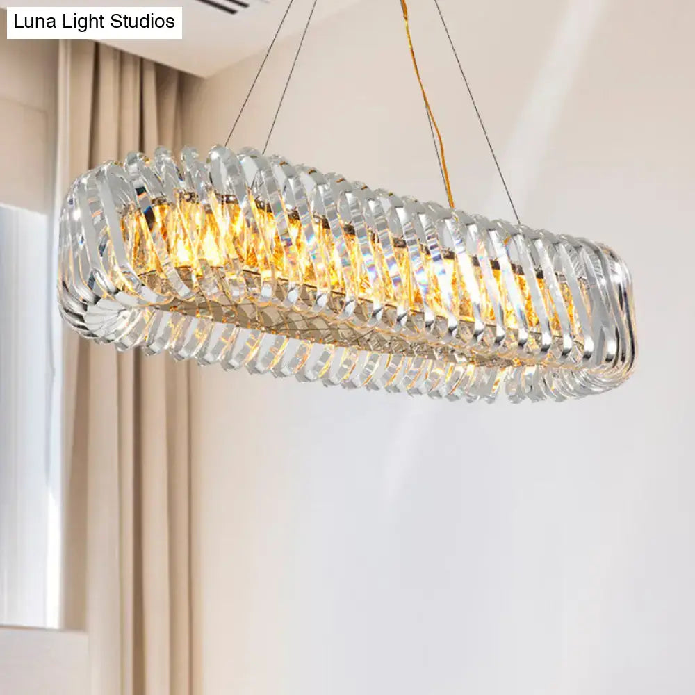 Modern gold pendant light with overlapping clear crystal prisms and warm led lights for dining room illumination