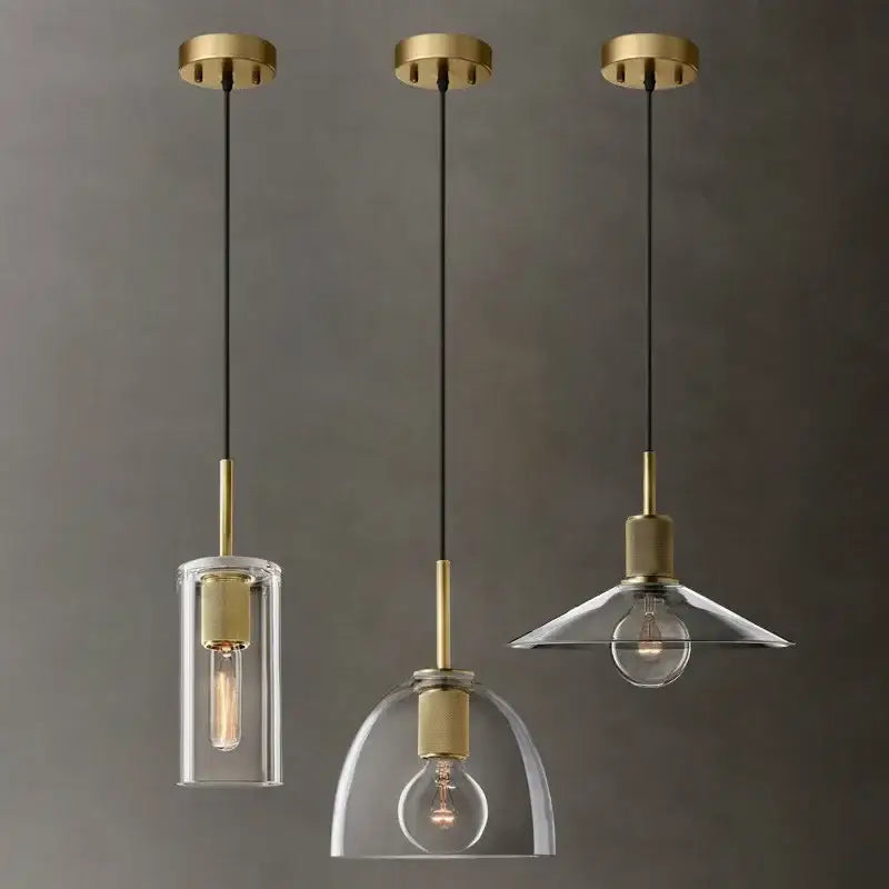 Modern gold and clear glass led pendant light trio with brass fixtures and exposed filament bulbs for dining room use