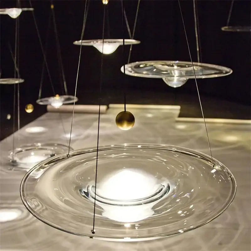 Modern gold and clear glass pendant light featuring a clear glass pendant with a central golden sphere by decorbites