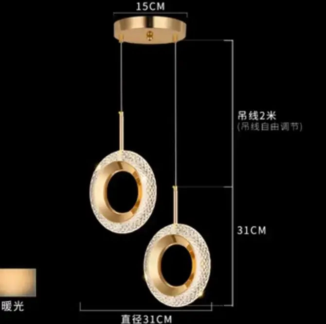 Modern gold and crystal oval bedside pendant light with two circular crystal-encrusted shades on adjustable cords