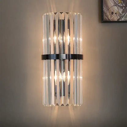 Modern gold and crystal wall light featuring vertical crystal prisms and a polished gold-toned metal band decorbites crystal wall