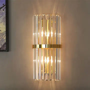 A modern gold and crystal wall light with vertical crystal rods and polished gold band for living room decorbites crystal wall