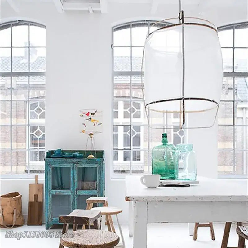 Modern gold and glass pendant light fixture with translucent white cylindrical shade and black metal framing for dining room decorbites bamboo linen