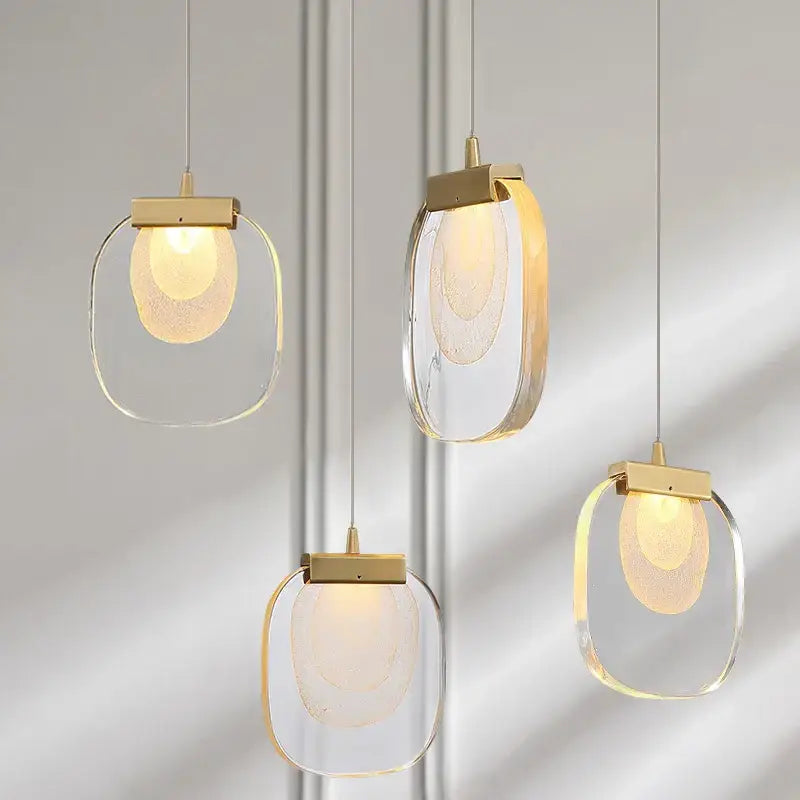 Modern gold and glass pendant lights featuring clear glass frames and frosted textured inner globes for dining rooms