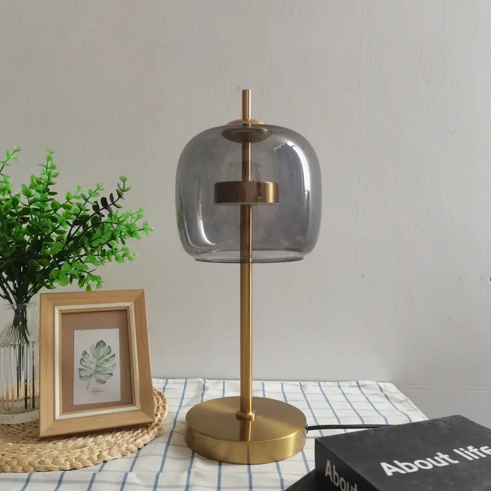 Modern gold and gray glass table lamp with brass finish and rounded smoked glass shade for bedroom decorbites decor
