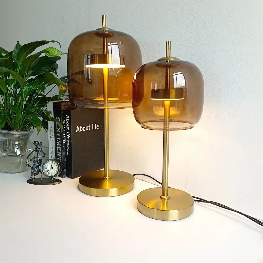 Two amber glass table lamps with brass bases featuring modern design as part of a bedroom glass table lamp set