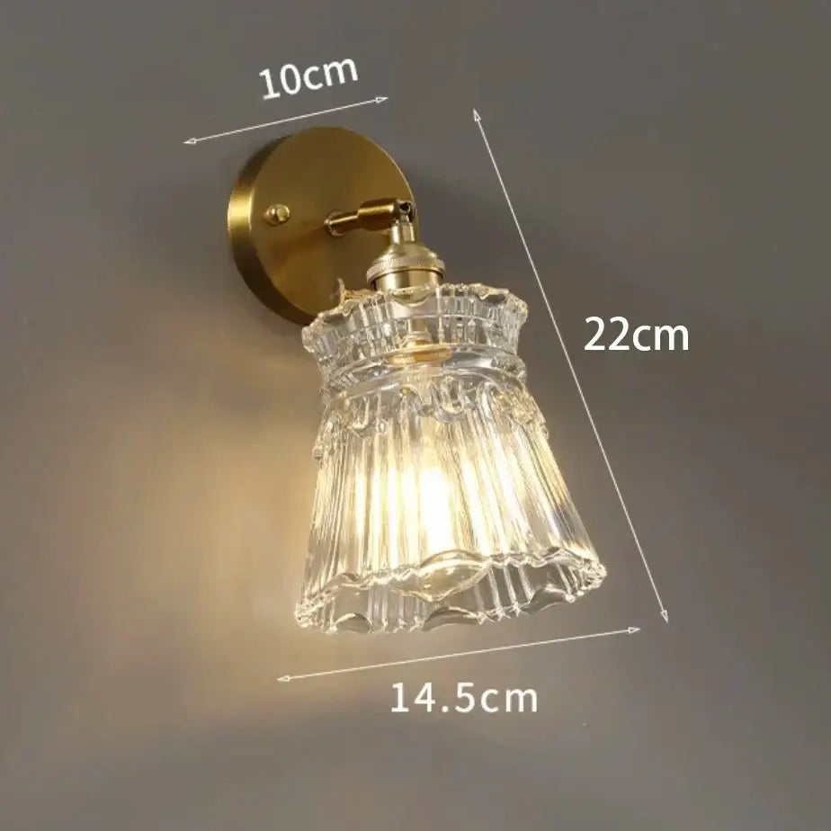 Modern gold and gray glass wall lamp with brass base and vertical ridged clear glass shade for living room use
