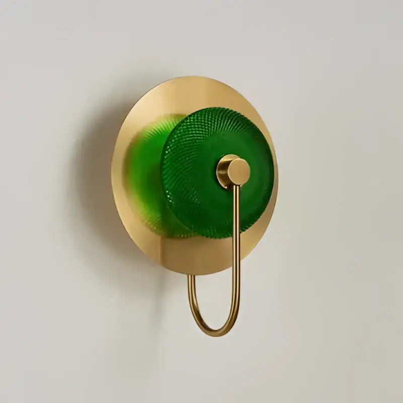 Modern gold and green glass wall sconce with polished brass finish and green mesh accent for bedroom lighting