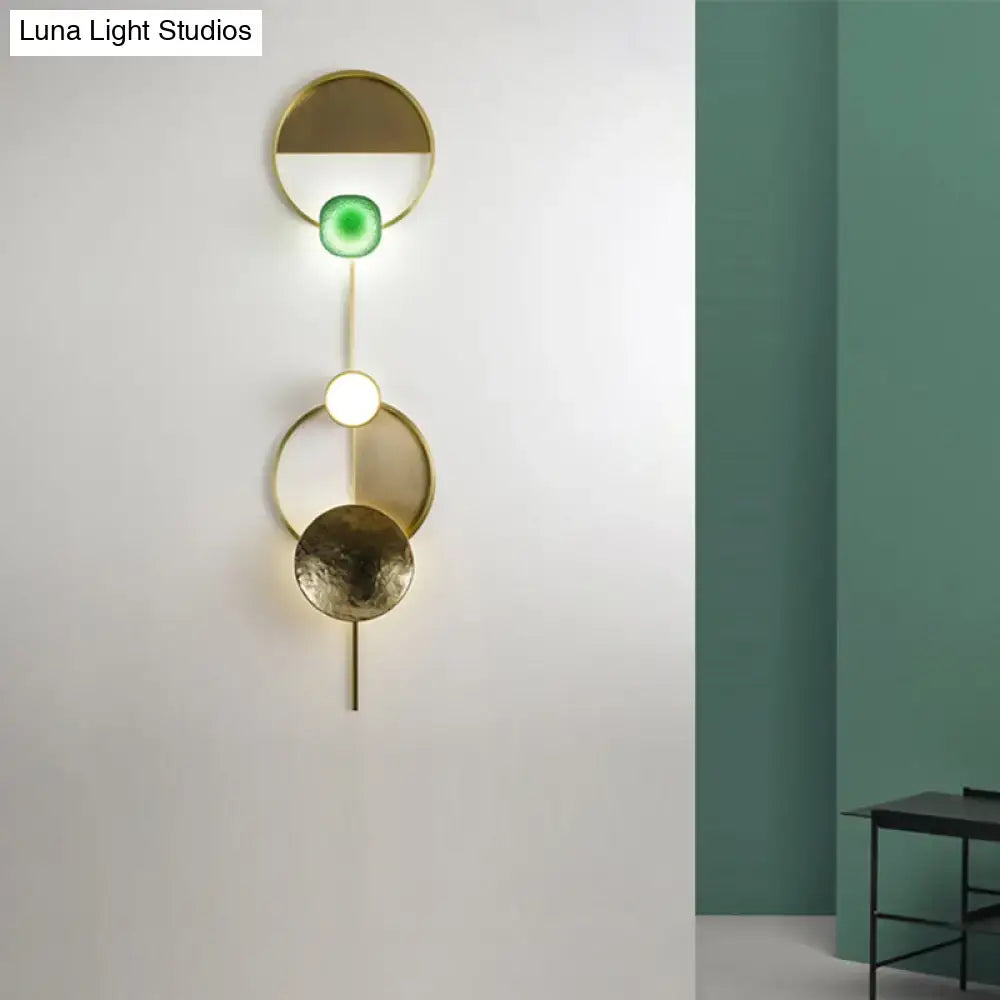 Modern gold and green orbit wall sconce wall lamp with stacked circular brass elements and glowing green accent light