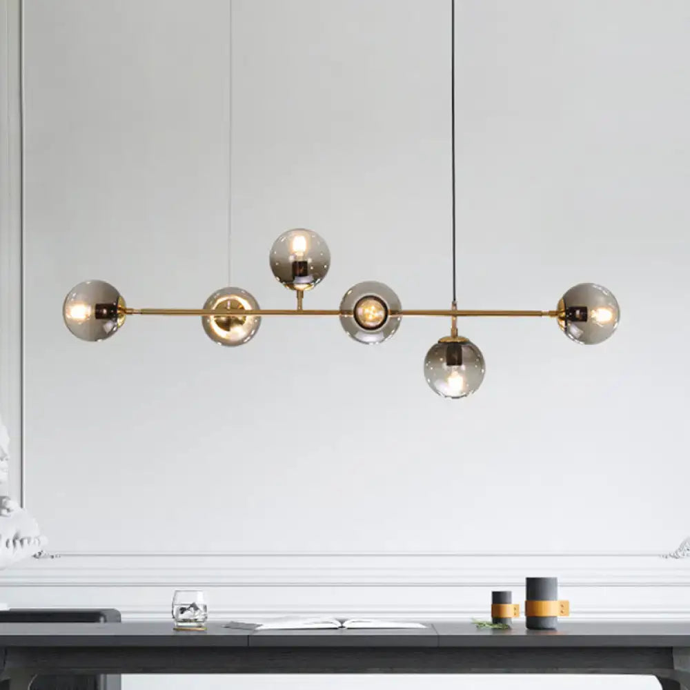 Modern gold and smoke gray globe hanging light with brass bar pendant and five smoked glass bulbs for dining room island