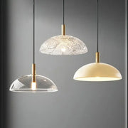 Three modern gold pendant lights with clear textured glass pendant shades ideal for kitchen and dining room lighting