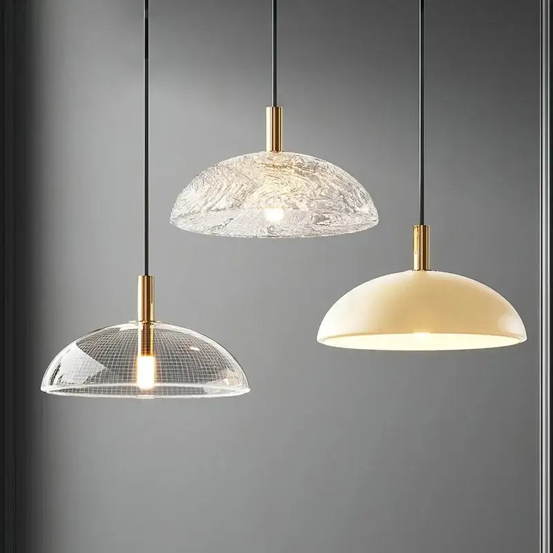 Three modern gold pendant lights with clear textured glass pendant shades ideal for kitchen and dining room lighting